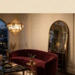 Neo Deco luxury living room with an arched brass mirror, burgundy velvet seating and geometric Art Deco details
