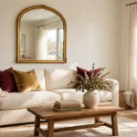 Luxury living room decorated on a budget with an oversized mirror, velvet cushions, warm layered lighting and a styled coffee table
